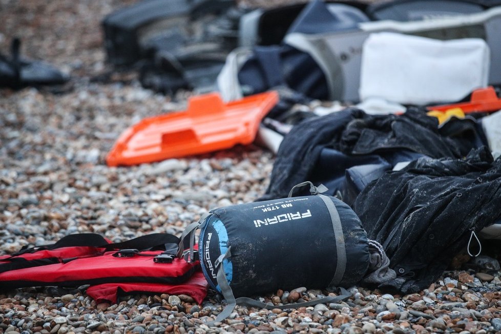 Zbytky poničeného člunu a osobních věcí zanechané na pláži nedaleko Wimereux. (25. 11. 2021)