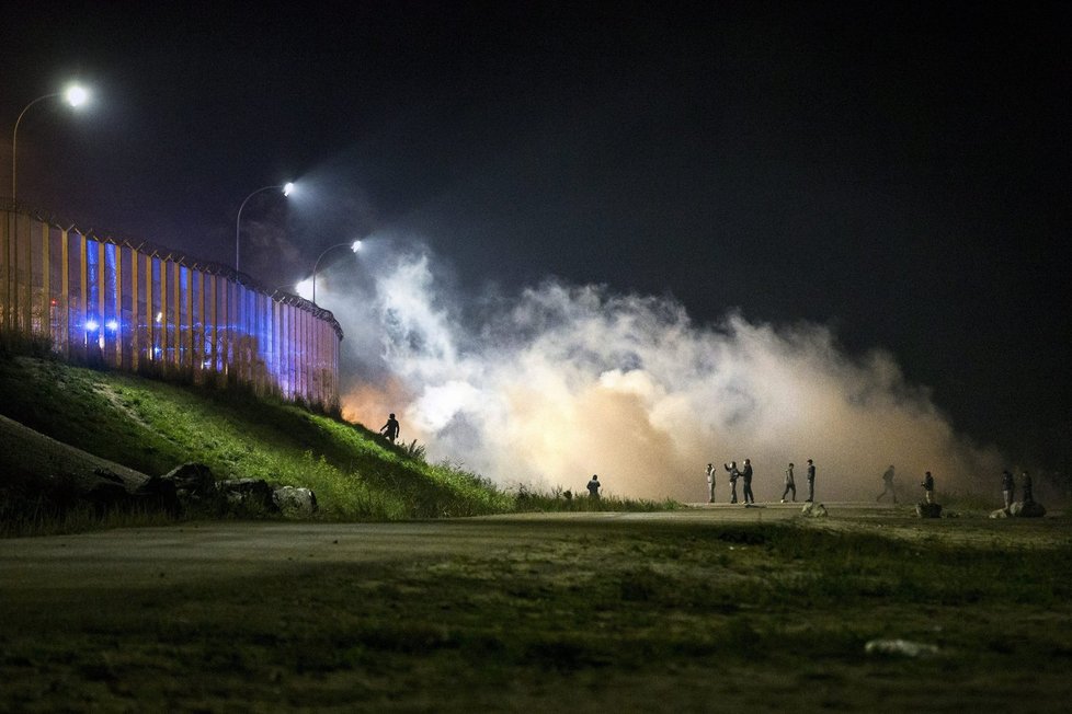 Utečenci měli na policii házet lahve a kamení, ta odpovídala kouřovými granáty. Tábor v Calais má být od pondělí bourán.
