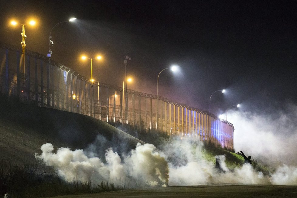 Utečenci měli na policii házet lahve a kamení, ta odpovídala kouřovými granáty. Tábor v Calais má být od pondělí bourán.