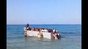 Turisté odtlačili loď s migranty zpět na moře