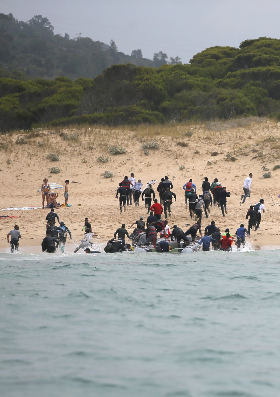 Migranti překonali Gibraltar a z Maroka připluli na jih Španělska. Po vylodění na pláži začali utíkat.