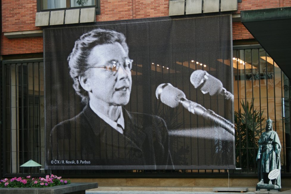 Plakát s podobiznou Milady Horákové a nápisem Zavražděna komunisty na budově Karolina.