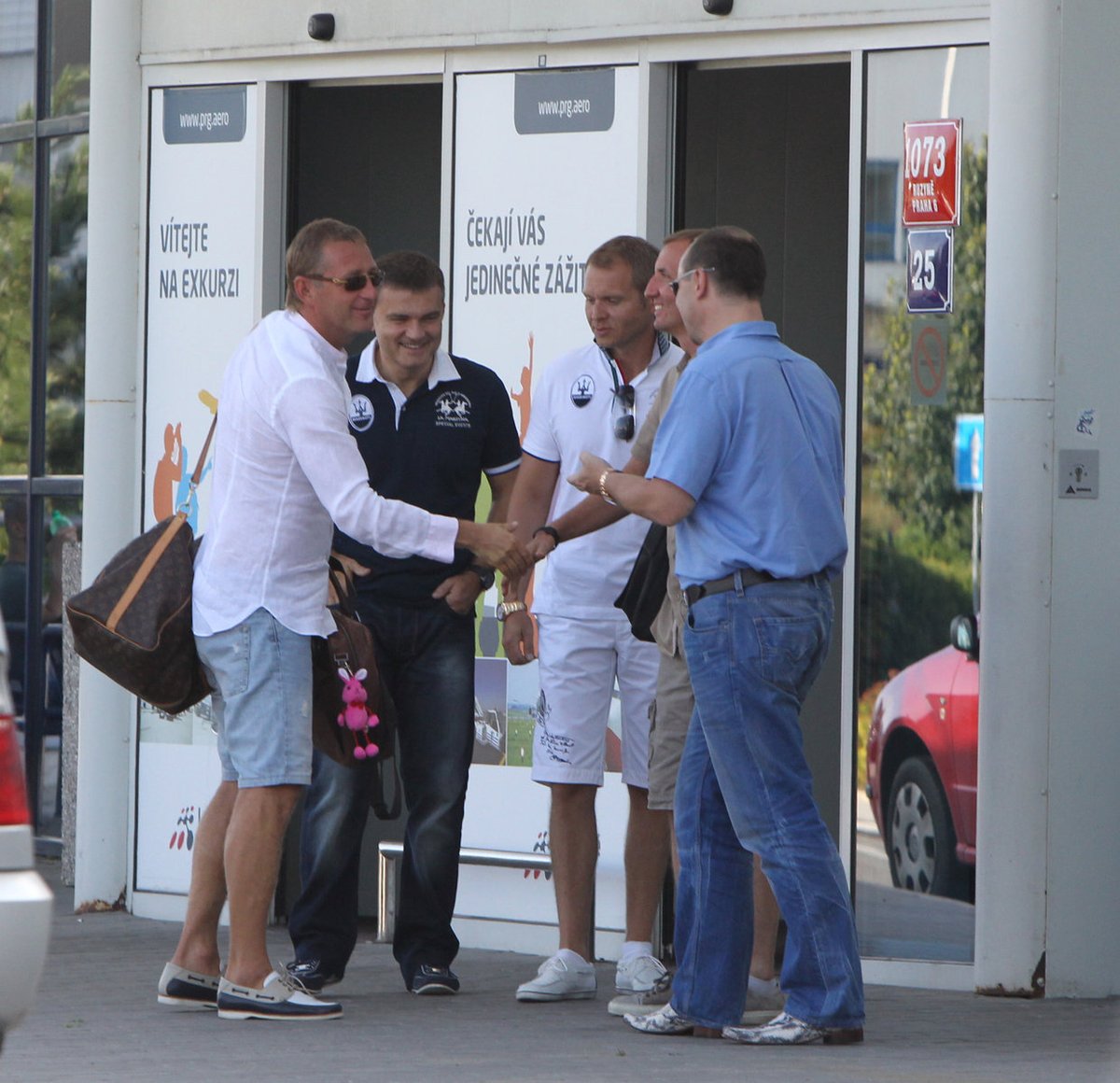 Přijel i Janoušek (vlevo v bílé košili), a celá parta je kompletní. Janoušek má na tašce růžového plyšáka, asi pro štěstí, aby šlapaly obchody!