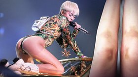 Miley Cyrus na pódium předvádí psí kusy. Z dlouhého klečení má bolavé modřiny na nohou.