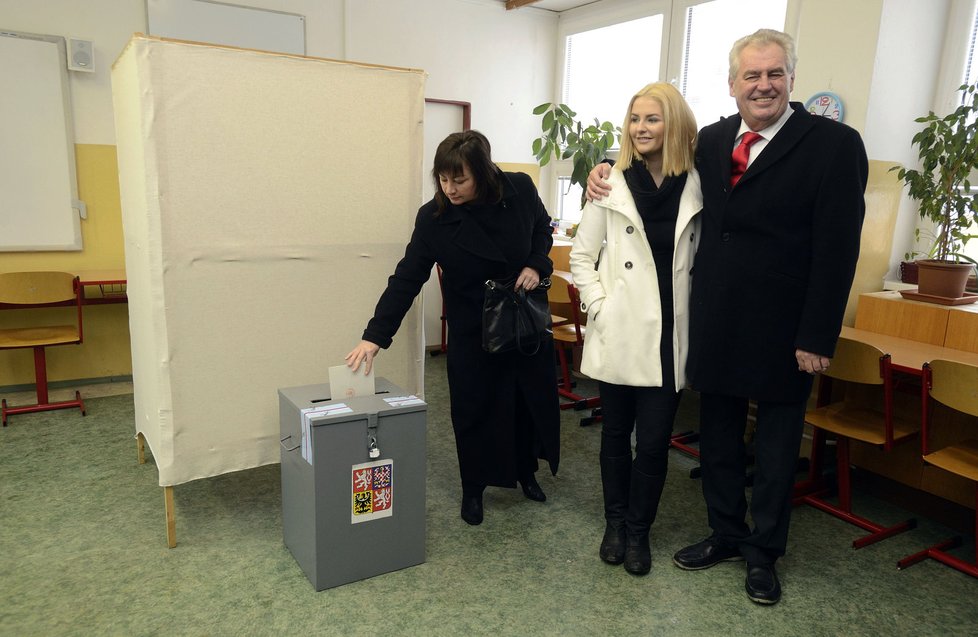 Miloš Zeman pózuje s dcerou Kateřinou, zatímco jeho manželka Ivana hází do urny svůj hlas.