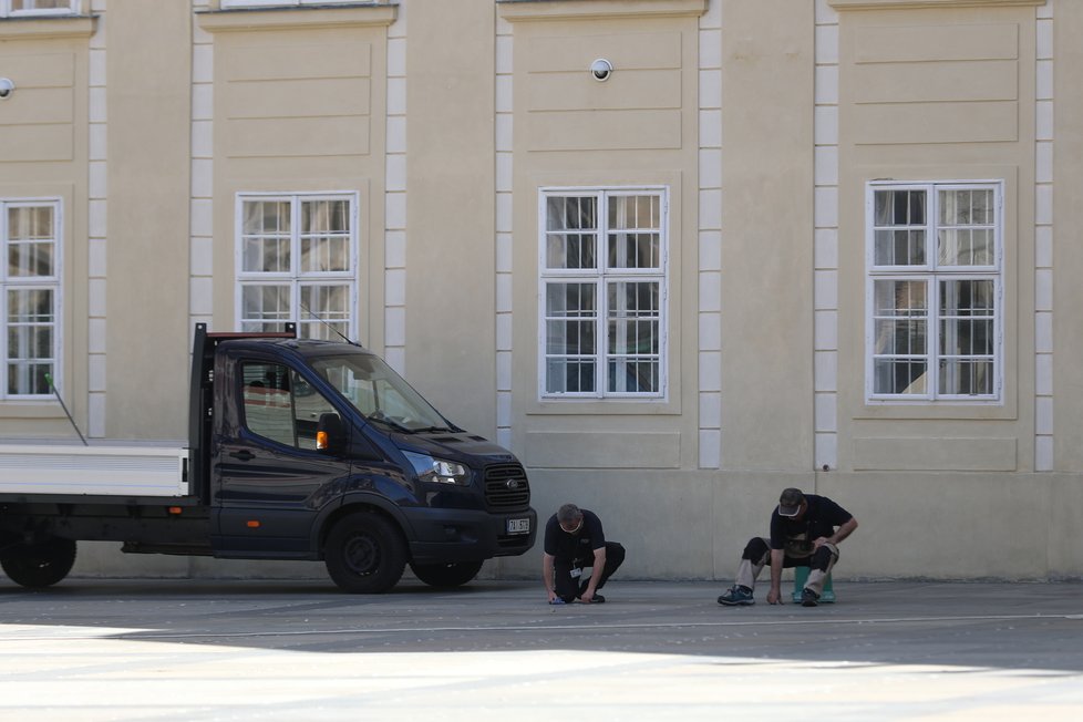 Úklid po Zemanově hradní pietě: Úklidová služba se snažila vypořádat s kousky oboustranné lepenky, která na svých místech držela kelímky (11.5.2021)