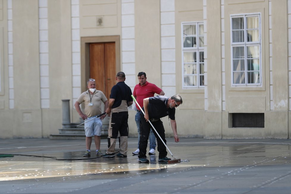 Úklid po Zemanově hradní pietě: Úklidová služba se snažila vypořádat s kousky oboustranné lepenky, která na svých místech držela kelímky (11.5.2021)