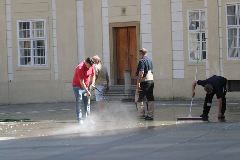 Úklid po Zemanově hradní pietě: Úklidová služba se snažila vypořádat s kousky oboustranné lepenky, která na svých místech držela kelímky (11.5.2021)