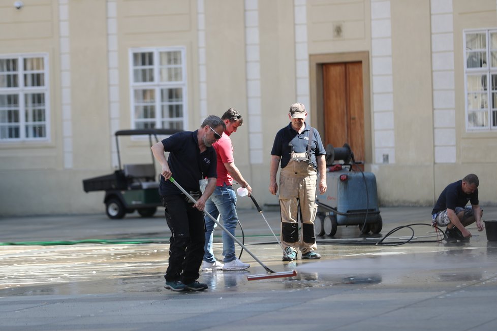 Úklid po Zemanově hradní pietě: Úklidová služba se snažila vypořádat s kousky oboustranné lepenky, která na svých místech držela kelímky (11.5.2021)