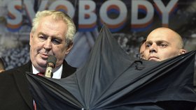 Prezident Zeman na Albertově, kde ho deštníky kryli členové ochranky před rozvášněnými odpůrci