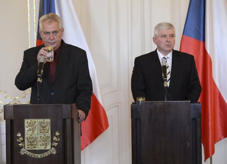 Miloš Zeman popíjí vodu během tiskové konference o situaci kolem dolu Paskov. Vpravo premiér v demisi Jiří Rusnok