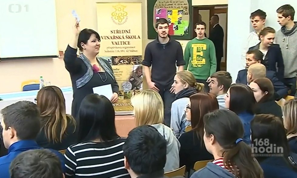 Beseda prezidenta se studenty ve Valticích v pořadu 168 hodin: Učitelka rozdává žákům otázky.
