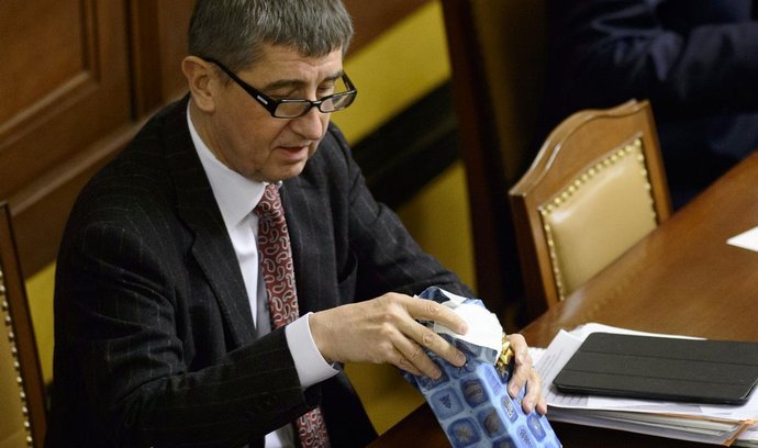Ministr financí Andrej Babiš rozbaluje dárek, který dostal 22. prosince na schůzi Sněmovny v Praze. Poslanci rozhodovali mimo jiné o novelách zákona o DPH proti daňovým únikům.