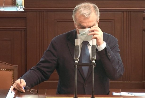 Miroslav Kalousek (TOP 09) při úpravě roušky během jednání Poslanecké sněmovny ke koronaviru (24.3.2020)