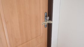 Zapečetěný byt a gumová rukavice vedle rohožky připomíná místo tragédie.