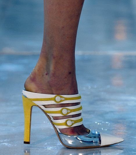 Tyto boty zn. Louis Vuitton jsou modelce evidentně těsné a malé – není divu, že jí noha ﬁaloví!