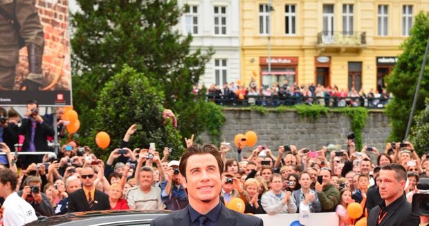 John Travolta celý den setrval v rozlehlém apartmá Grandhotelu Pupp a z limuzíny vystoupil sám. Reportéři na místě děje hlásí, že davy za provazy šílí, ale jeho outfit spíš nudí. A odborník na etiketu by jistě poznamenal, že mokasíny jsou na takovou společenskou akci nevhodné. Ty by si měl John nechat na garden party v Hollywoodu.