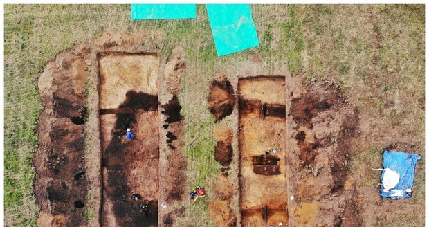 Pohled z dronu na archeologické sondy na mohyle ve Vražkově. Tmavé linie značí obvodové příkopy mohyly, tmavý obdélník mezi nimi v pravé sondě je jedním z odkrytých hrobů.
