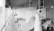 Zdravotní sestra měřící puls pacientovi na chřipkovém oddělení.