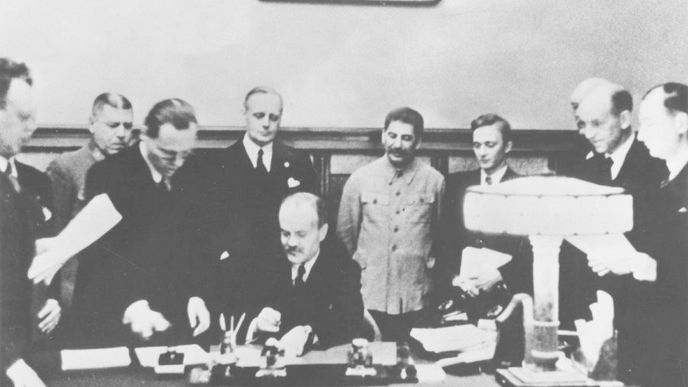 Molotov podepisuje německo-sovětskou smlouvu o neútočení. Ribbentrop je v pozadí v černém.