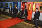 Mongolský prezident vystupuje za asistence hradního protokoláře Jindřicha Forejta z vlaku na červený koberec.