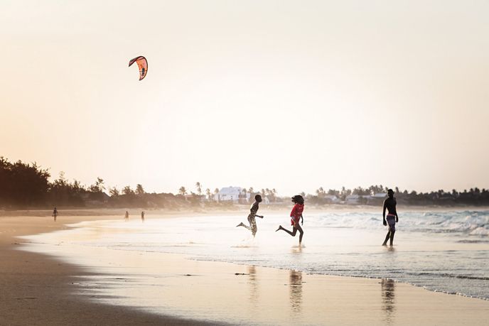 Místní děti si hrají u vody na pláži Praia de Tofo Místní děti si hrají u vody na pláži Praia de Tofo