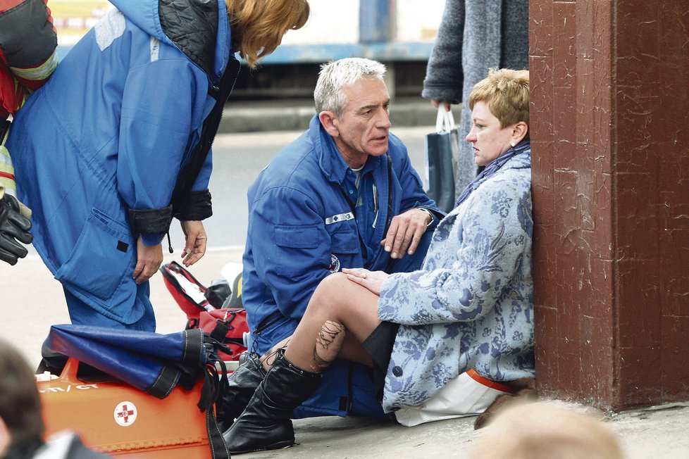 Záchranář ošetřuje ženu, která byla v době výbuchu v metru.