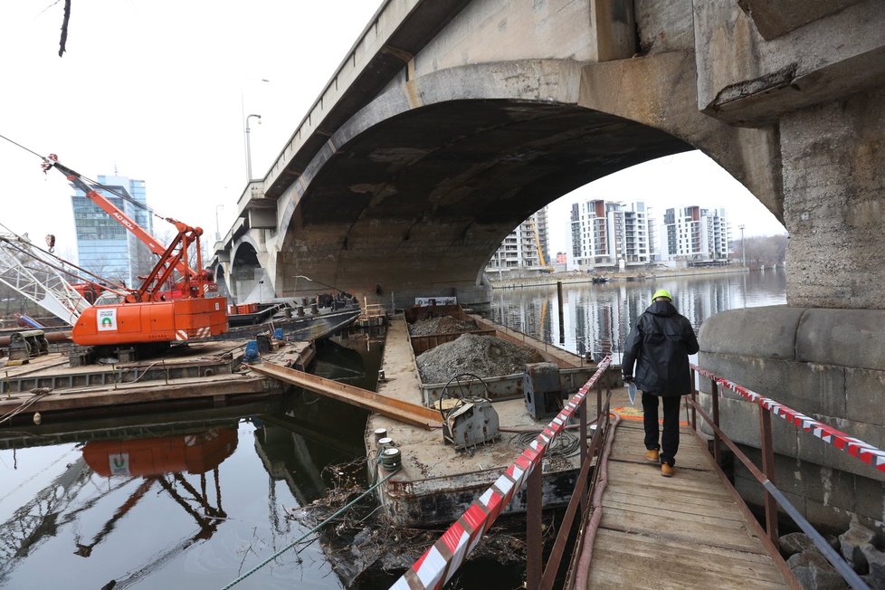 Přímo na Vltavě pod Libeňským mostem se nachází těžká technika a lodě.