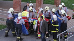 Záchranáři transportují vážně zraněného dělníka do nemocnice