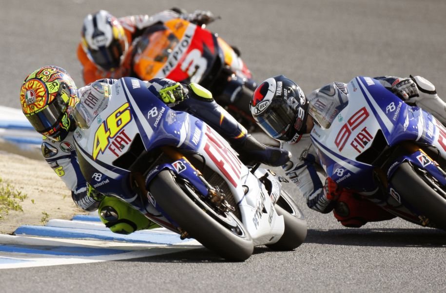 Valentino Rossi (č. 46) z tímu Yamaha sa bije o prvé miesto s tímovým kolegom Jorge Lorenzom (č. 99). Za nimi je Španiel Dani Pedrosa z tímu Honda