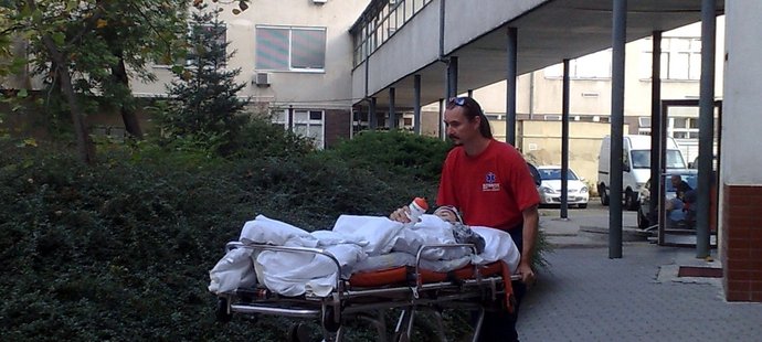 Řidič sanitky převáží Lukáše Šemberu z brněnské Úrazové nemocnice k převozovému vozu.