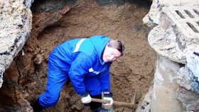 Pracovník Brněnských vodáren a kanalizací odkopává krumpáčem zeminu u prasklého potrubí v Rolnické ulici na sídlišti v Brně-Bohunicích.