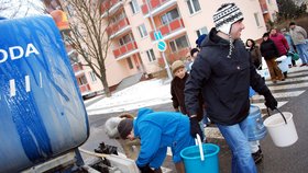 Muž si odnáší v kbelících vodu z cisterny na sídlišti Řezáčova v brněnské čtvrti Komín.