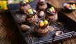 Čokoládové muffiny ozdobte krémem, hnízdečky z rozlámaných tyčinek obalených v rozehřáté čokoládě a čokoládovými vajíčky.