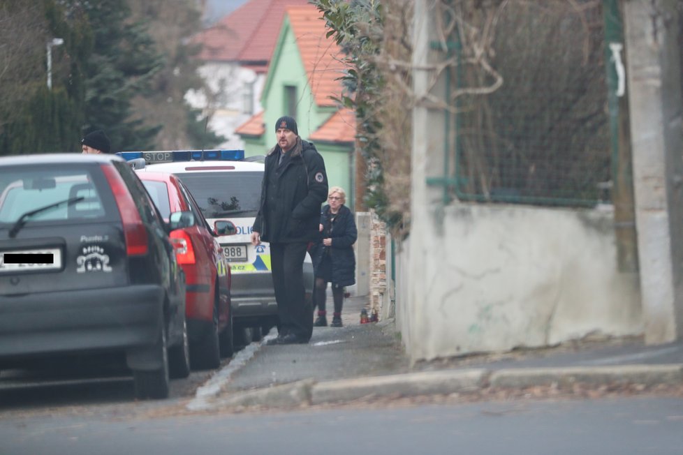 Rodina odjíždí za asistence policie k Národnímu divadlu, kde proběhne rozloučení s Luďkem Munzarem.