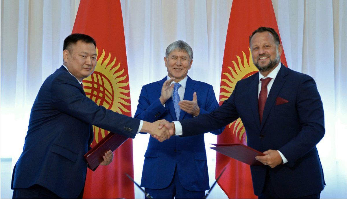 Michal Smelík (vpravo) stvrzuje smlovu se zástupcem kyrgyzské vlády. Tleská jim prezident Almazbek Atambajev.