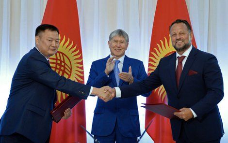 Michal Smelík (vpravo) stvrzuje smlovu se zástupcem kyrgyzské vlády. Tleská jim prezident Almazbek Atambajev.