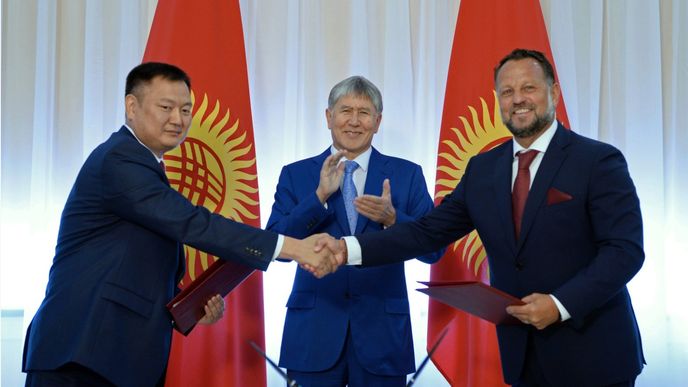 Michal Smelík (vpravo) stvrzuje smlouvu se zástupcem kyrgyzské vlády. Tleská jim prezident Almazbek Atambajev.