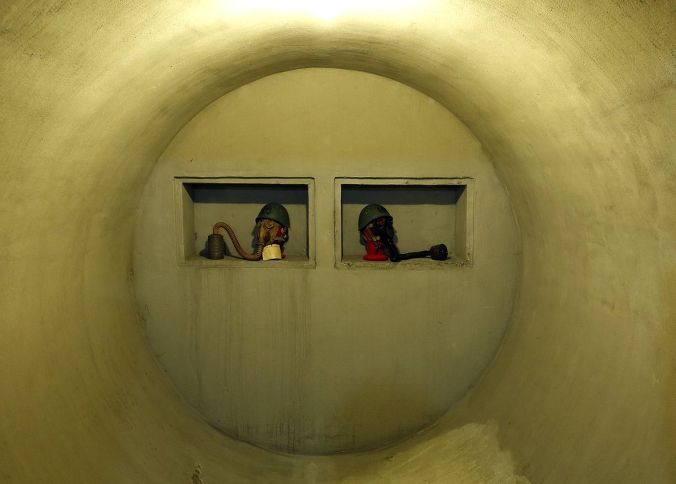 Helmy a plynové masky uvnitř tjaného bunkru.