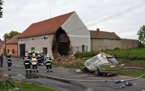 Pobořený dům a vůz, v němž řidič zahynul.