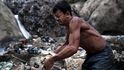 Muž plní pytel kovovým odpadem nasbíraným v chemicky kontaminované vodě na dně guatemalské skládky.
