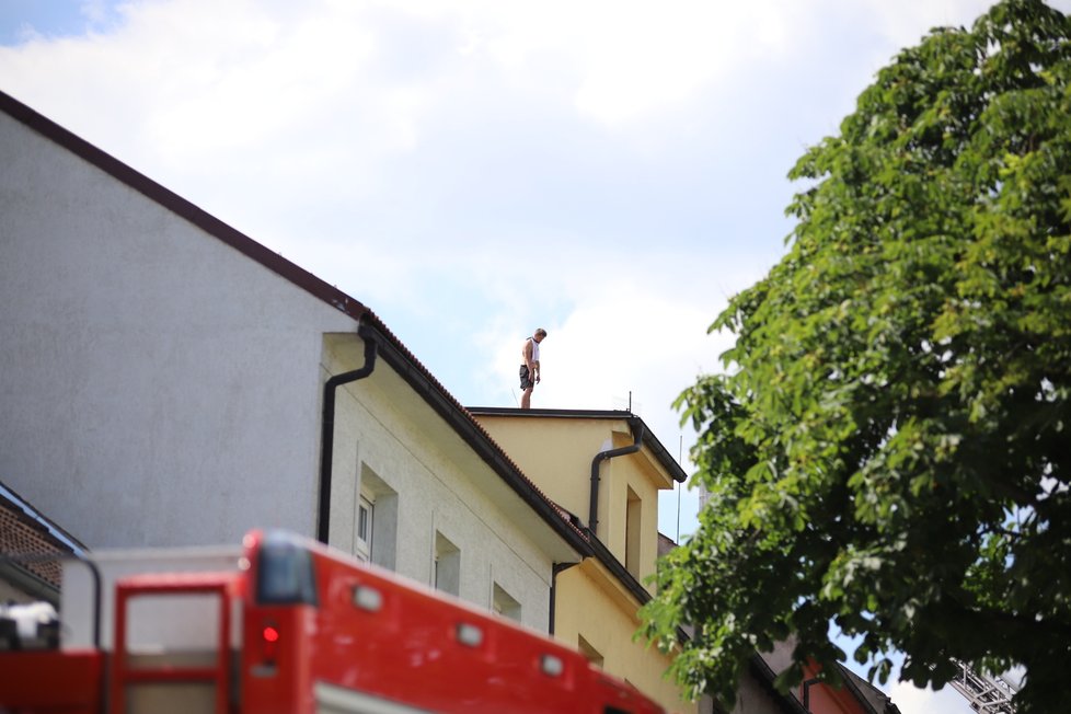 Muž v Malešicích běhal po střeše domu a odmítal slézt, na místě zasahovali policisté i hasiči.