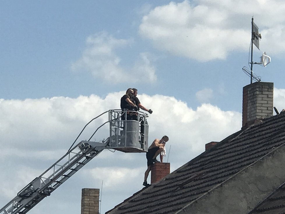 Muž v Malešicích běhal po střeše domu a odmítal slézt, na místě zasahovali policisté i hasiči.