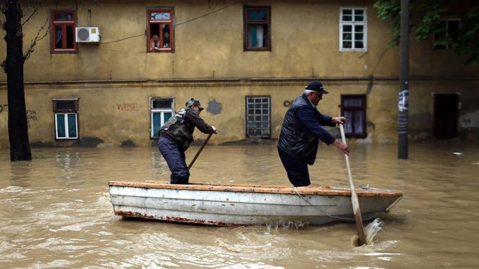 Muži pádlují po zaplavené ulici v srbském městě Obrenovač