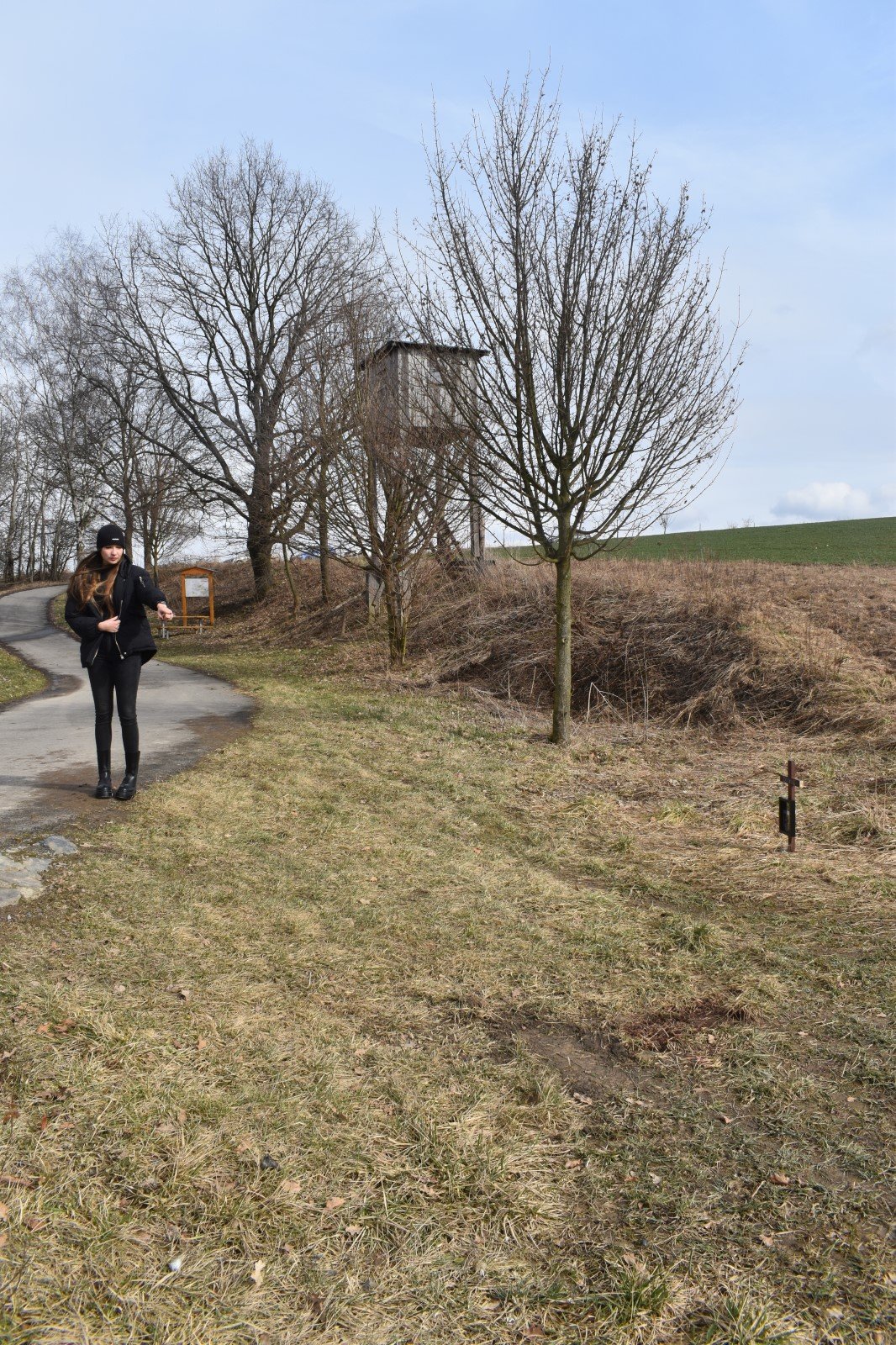 Dívka ukazuje k místu, kde byla Dixie střelena, jen pár metrů od cyklostezky. V pozadí osudný posed.