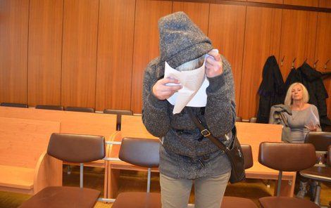 Žena si u soudu skrývala tvář.