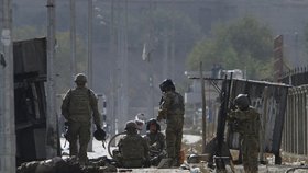 Vojáci NATO sedí obklopeni obětmi sebevražedného útoku.