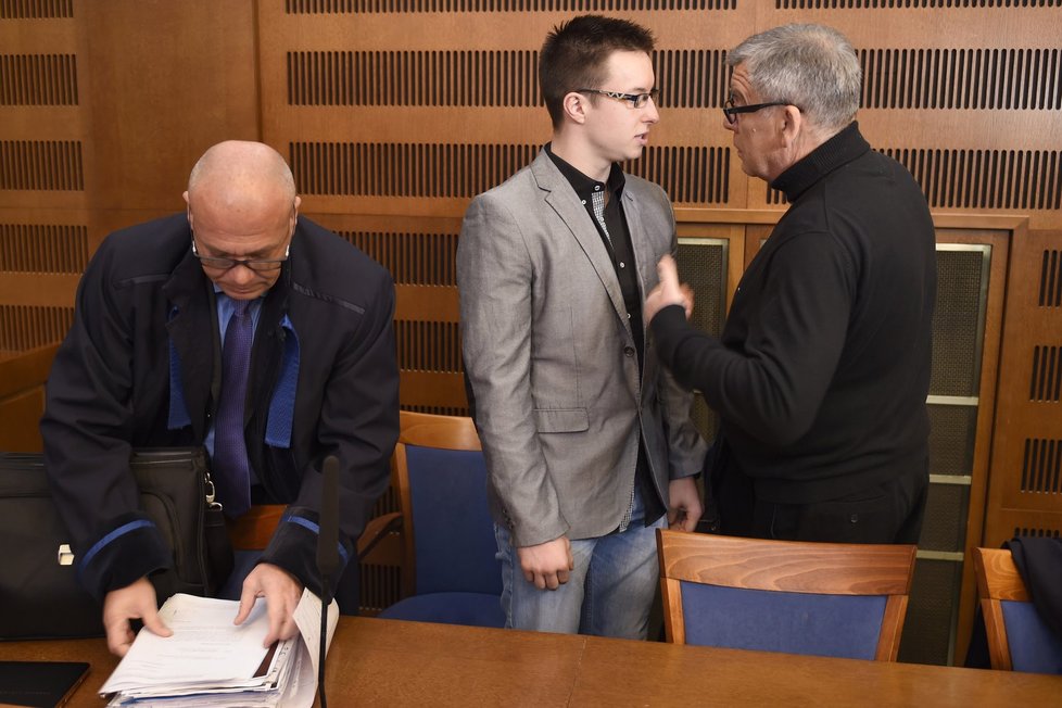 Obžalovaný Lukáš Nečesaný (uprostřed) hovoří 1. dubna se svými obhájci v soudní síni před jednáním u hradeckého krajského soudu.
