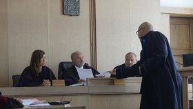 Obhájce Nečesaného předkládá soudci důležité dokumenty.