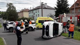 Vůz Dacia skončil po srážce na boku. Zraněná byla řidička i dvě malé děti.